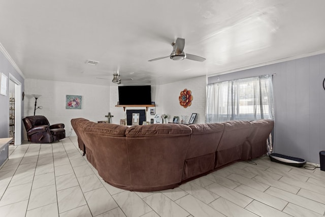 living area with visible vents, ornamental molding, and a ceiling fan