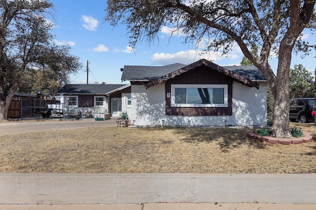 single story home featuring brick siding and a front yard