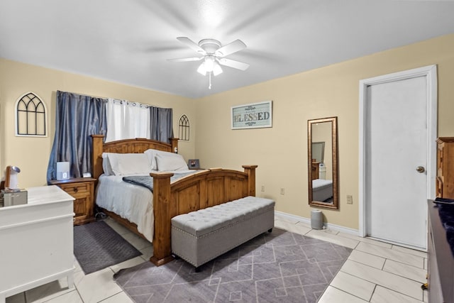 tiled bedroom with a ceiling fan and baseboards