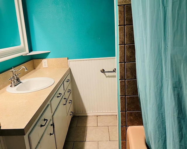 bathroom with shower / bath combo with shower curtain, tile patterned flooring, and vanity