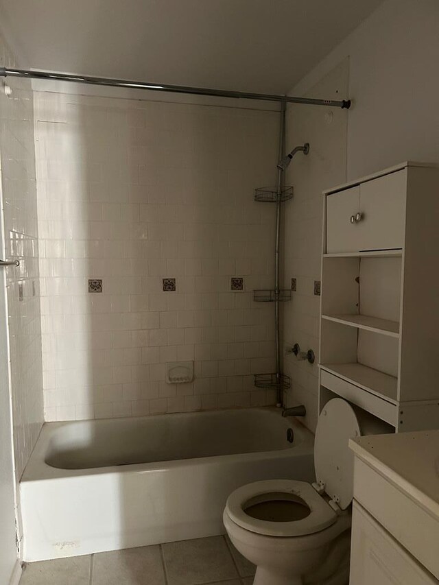 full bathroom featuring tile patterned flooring, vanity, toilet, and tiled shower / bath combo