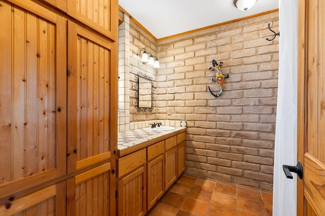 bathroom with brick wall and vanity