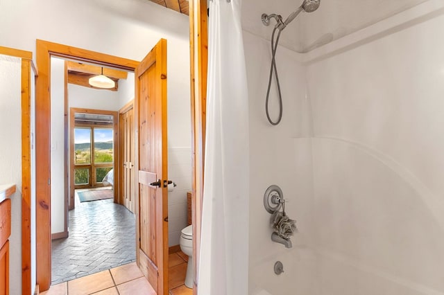 bathroom with toilet, shower / bath combination, and tile patterned flooring