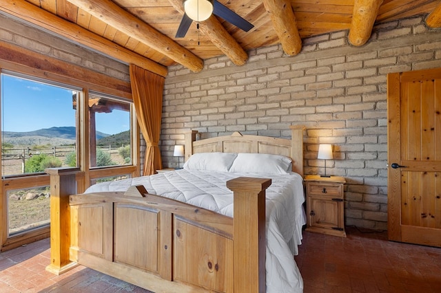 bedroom with beamed ceiling, wood ceiling, brick wall, and a mountain view