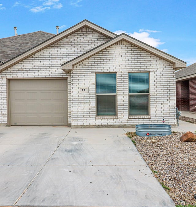 ranch-style home featuring an attached garage, brick siding, and driveway