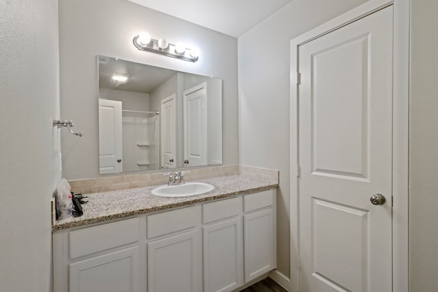 bathroom featuring a shower and vanity