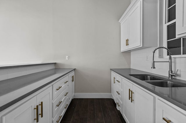 kitchen with sink, dark wood-type flooring, white cabinets, and backsplash