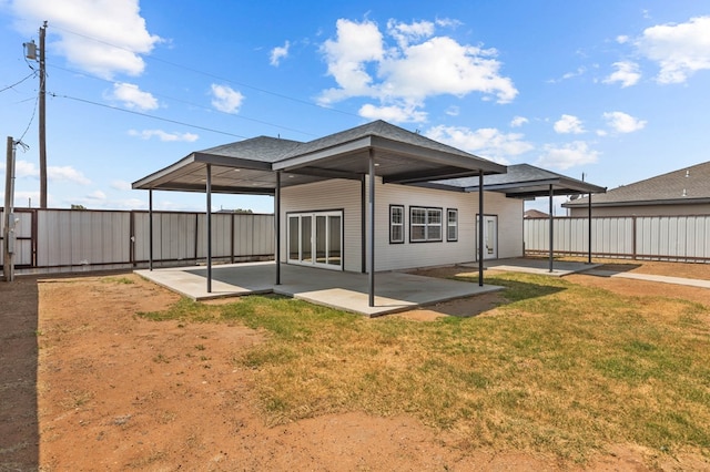 back of property with a lawn and a patio