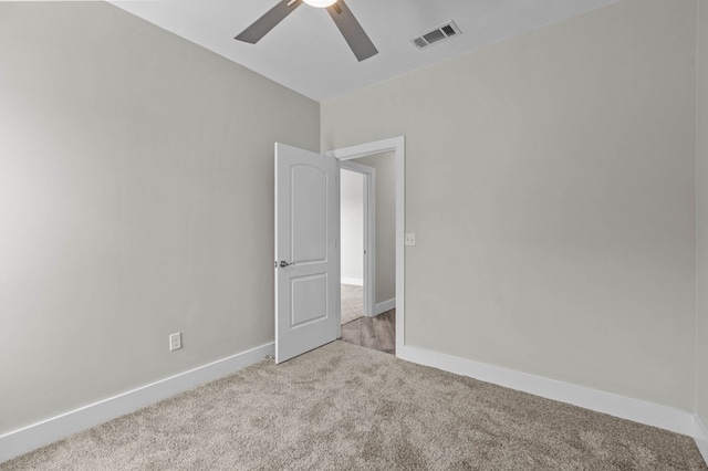 carpeted spare room with ceiling fan