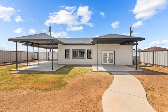 rear view of property featuring french doors, a patio, and a lawn