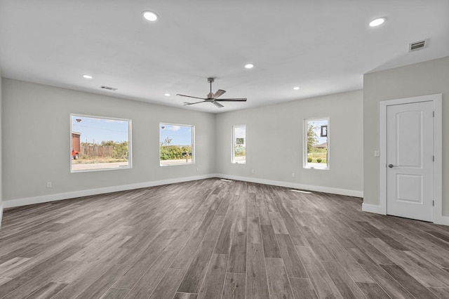 spare room with plenty of natural light, hardwood / wood-style floors, and ceiling fan