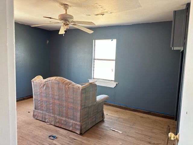 living area featuring light wood-type flooring and ceiling fan