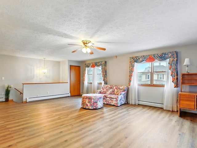 702/704 S Wilbur Ave, Sayre, PA 18840 - sitting room with a baseboard heating unit, wood finished floors, an upstairs landing, ceiling fan, and a textured ceiling