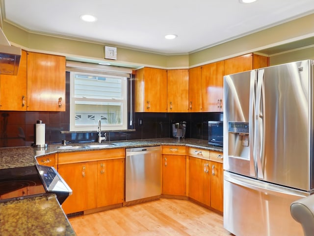 702/704 S Wilbur Ave, Sayre, PA 18840 - kitchen featuring appliances with stainless steel finishes, a sink, brown cabinets, light wood-style floors, and backsplash
