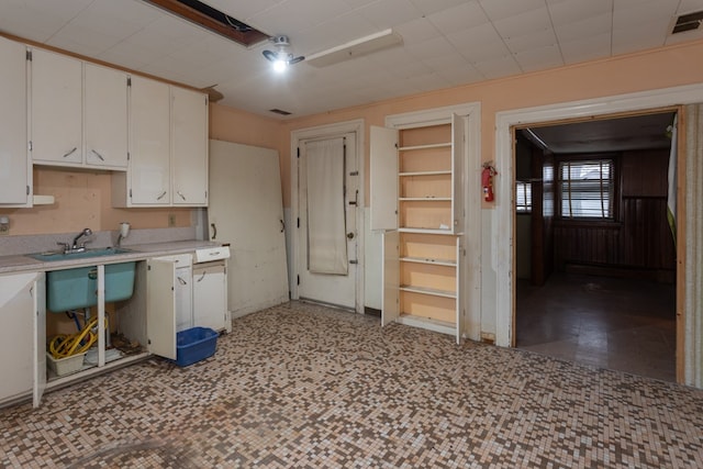 kitchen featuring white cabinetry and sink