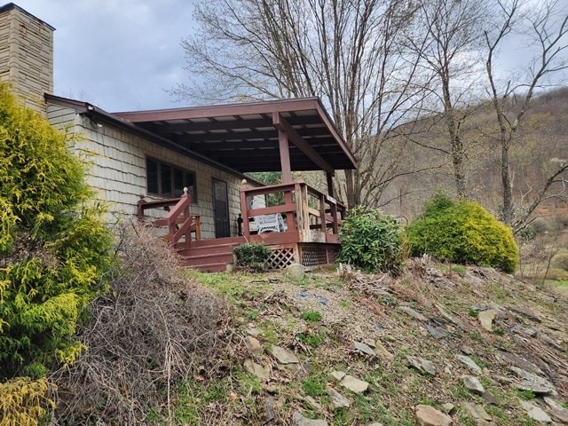 view of home's exterior featuring a wooden deck and a chimney