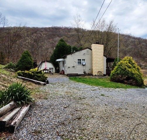 view of home's exterior featuring a chimney and an outbuilding