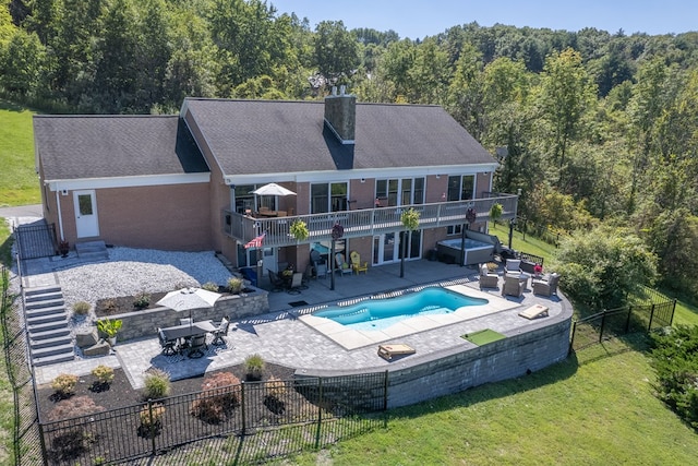 back of property with outdoor lounge area, a swimming pool with hot tub, a yard, and a patio