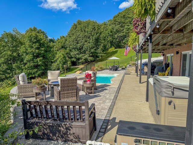 view of pool featuring a patio and a hot tub