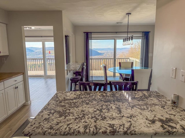 dining area featuring a mountain view, light hardwood / wood-style floors, and a notable chandelier