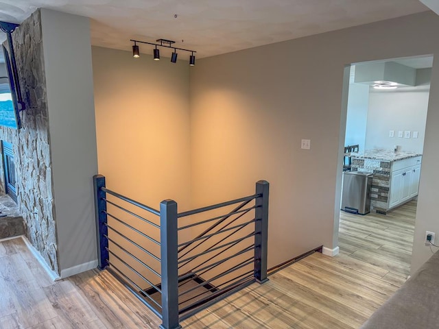 hall featuring light hardwood / wood-style floors and track lighting