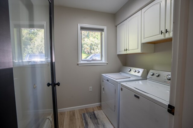 laundry area featuring washer and dryer, cabinets, and light hardwood / wood-style floors