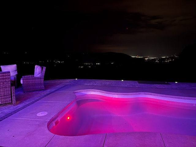 pool at night with a patio