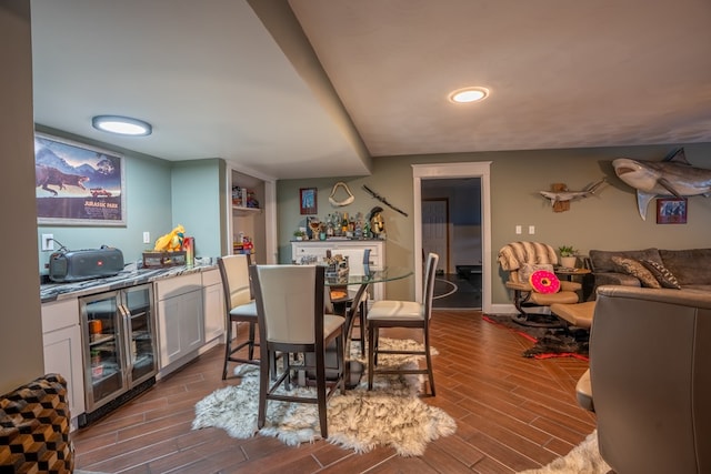 dining room with wine cooler, built in shelves, and indoor bar