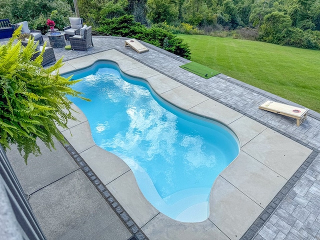 view of swimming pool featuring a patio area and a yard