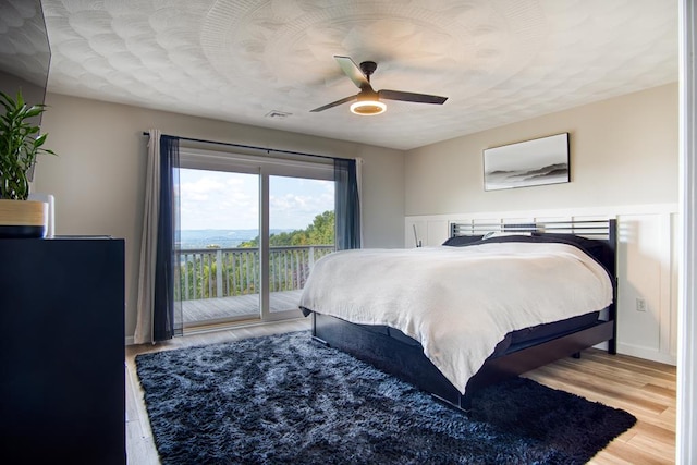 bedroom with ceiling fan, access to exterior, and wood-type flooring