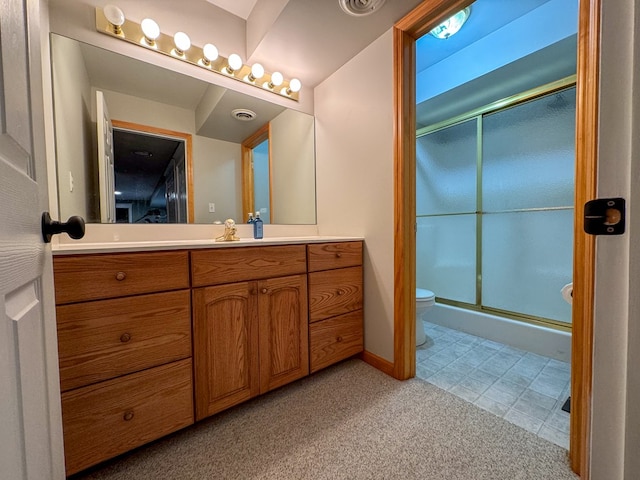 bathroom with a shower with door, vanity, and toilet