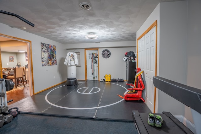 workout room featuring a textured ceiling