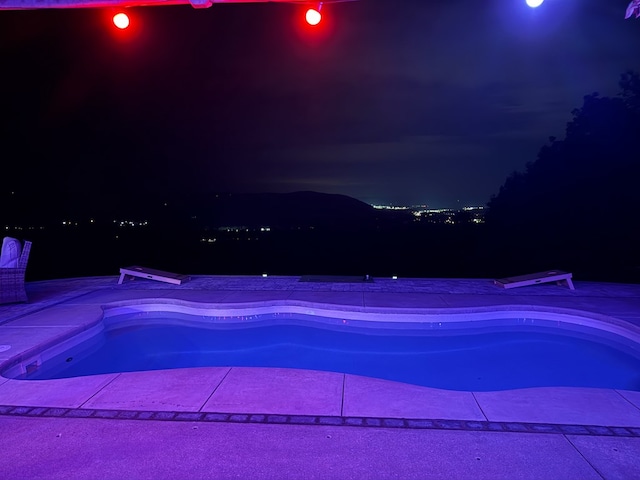 view of swimming pool with a diving board