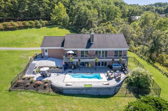 rear view of property featuring a lawn, an outdoor living space, a fenced in pool, and a patio