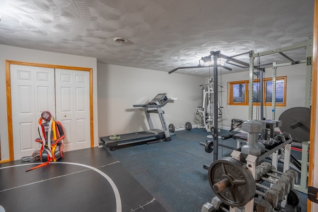 exercise room with a textured ceiling