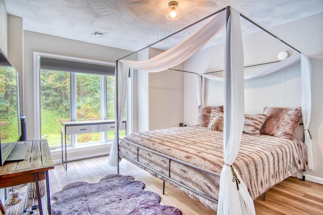 bedroom with light hardwood / wood-style flooring and ceiling fan