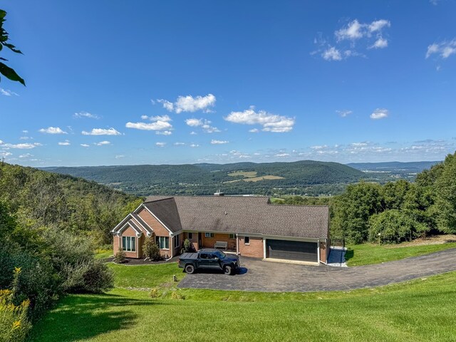 exterior space with a mountain view, a front yard, and a garage