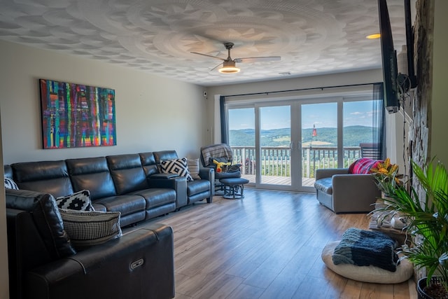 living room with light hardwood / wood-style flooring and ceiling fan