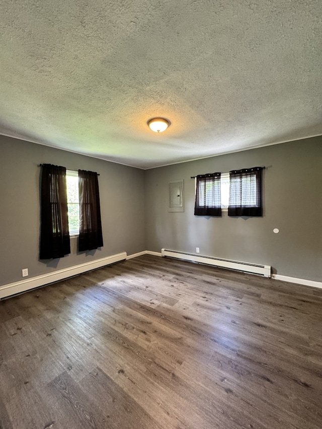 109 Main St, Roulette, PA 16746 - unfurnished room featuring a baseboard heating unit, a textured ceiling, wood finished floors, baseboards, and electric panel