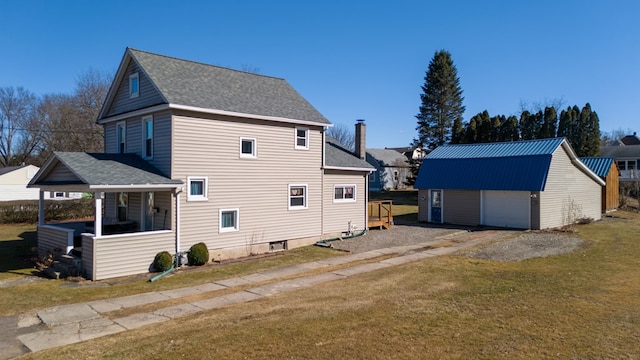 rear view of property featuring an outbuilding, roof with shingles, a porch, a yard, and a garage