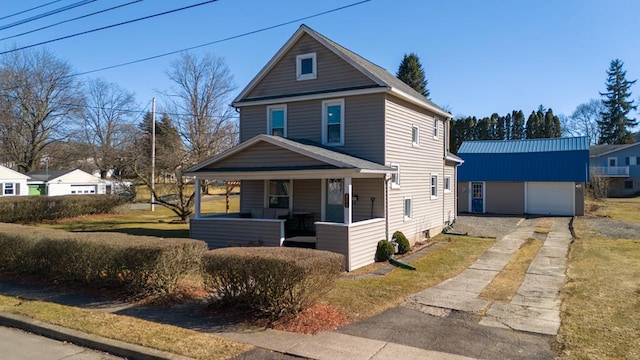 view of front of home featuring an outbuilding, a garage, covered porch, and driveway