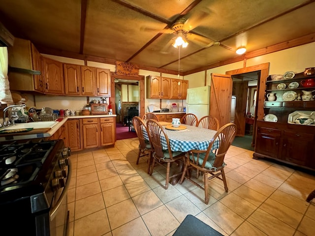 kitchen featuring ceiling fan, white fridge, light tile patterned floors, and sink