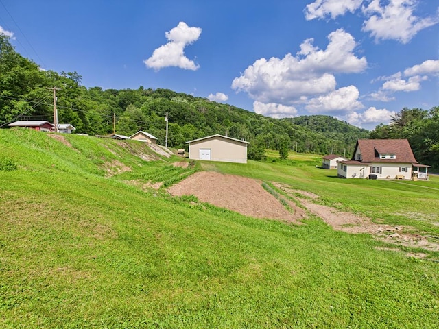 40 W Hebron Rd, Coudersport, PA 16915 - view of grassy yard with driveway, a mountain view, and a garage