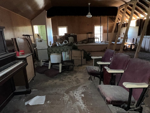 misc room with lofted ceiling and concrete floors