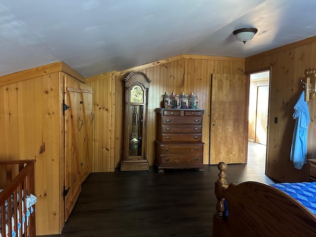 bedroom featuring dark hardwood / wood-style flooring and wood walls