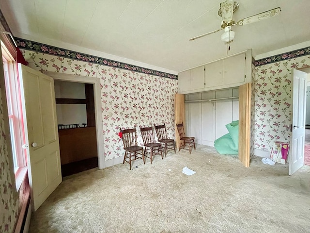 unfurnished bedroom featuring light carpet and ceiling fan