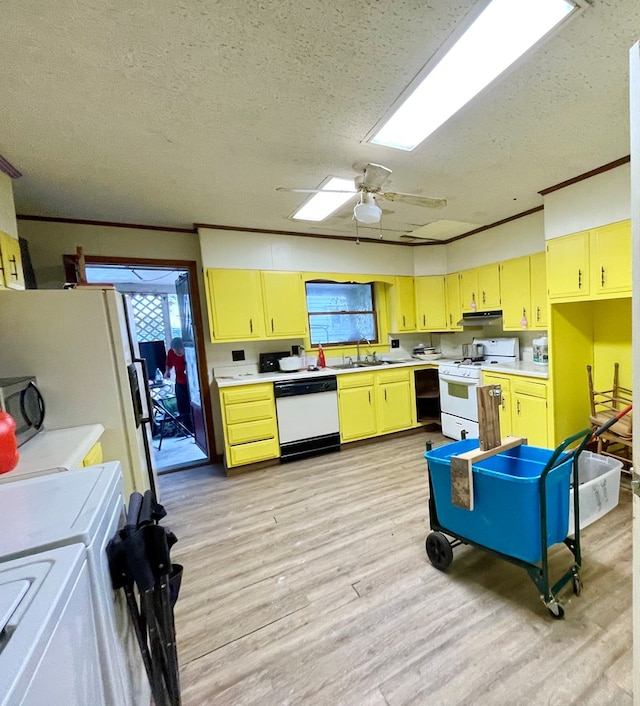 kitchen with washer and clothes dryer, white appliances, a textured ceiling, and ornamental molding