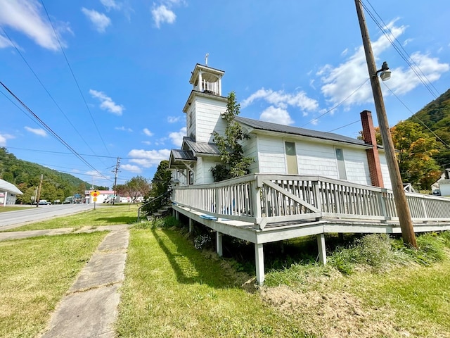 back of house featuring a wooden deck and a yard