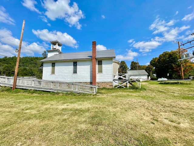 rear view of house featuring a lawn