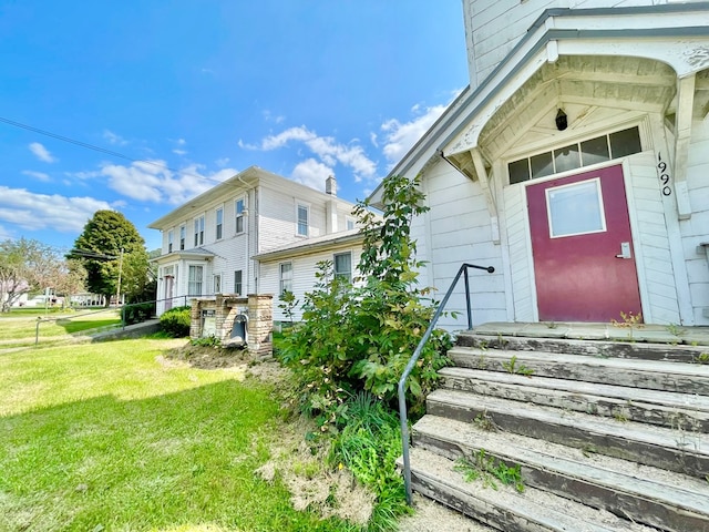 property entrance with a lawn